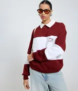 Saco de tejido de punto color bordó y blanco, con cuello polo blanco y tapeta de botones. Presenta un estampado de texto en el pecho.