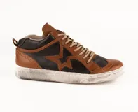Zapatilla de cuero vacuno con diseño bicolor en marrón y negro. Presenta un aplique de estrella en el lateral, detalles de costuras y perforaciones decorativas tipo brogue. Cuenta con suela de goma con efecto desgastado y cordones al tono.