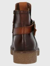 Bota corta de cuero vacuno color marrón con acabado envejecido, presenta una tira decorativa con hebilla metálica en el tobillo y una suela de plataforma de goma texturizada.