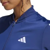 Conjunto deportivo Adidas Essentials 3 Rayas azul marino con detalles en blanco. Incluye campera con cierre frontal, cuello alto y pantalón con cintura elástica.