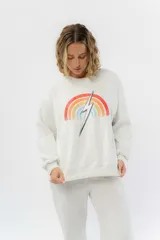 Buzo gris melange de algodón con felpa suave por dentro, cuello redondo y puños ajustados. Estampa frontal de arcoíris con rayo al centro.