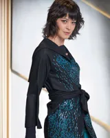 Túnica negra de gabardina de lana con capucha y estampado artesanal.