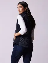 Chaleco capitoneado color beige, marca Gallery. Con abertura central con cierre, bolsillos delanteros con cierre, laterales en tejido elastizado y forro interno a tono.