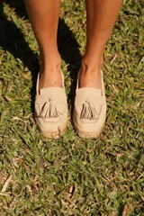 Slip on de gamuza color beige, con detalle de flecos en el empeine y suela de yute trenzado.