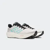 Championes de running New Balance Fresh Foam X 1080 V13, color gris claro con detalles en turquesa y negro. Presentan una entresuela gruesa de espuma blanca con tecnología Fresh Foam X y logo "N" lateral en turquesa.
