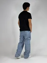 Pantalón de jean celeste con lavado ácido, corte ancho (baggy) y múltiples bolsillos cargo.
