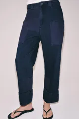 Pantalón worker de tiro medio de Zara Woman Collection, confeccionado en denim azul oscuro con detalles de combinación de tejidos a tono. Presenta cintura con trabillas, bolsillos laterales de plastrón, bajo acabado en vuelta y cierre frontal con cremallera y botón.
