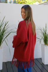 Saco abierto tipo capa en color bordó, confeccionado en tejido de punto suave, con mangas amplias y detalle de flecos en el ruedo.