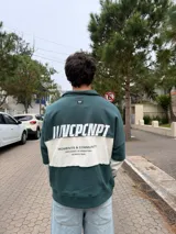 Buzo tipo polo de corte relajado y fit boxy, con diseño de bloques de color en bordó y blanco. Presenta cuello camisero con cierre frontal parcial y logo bordado en el pecho.