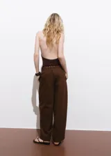 Pantalón largo color marrón, de corte recto y holgado, con cintura elástica fruncida y cordón ajustable.