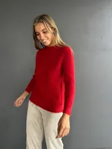 Sweater de punto color rojo con diseño de ochos en el frente y tejido morley en mangas y espalda. Presenta cuello redondo a la base, manga larga y calce ajustado.