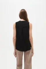 Musculosa de poliéster color blanco, con cuello en V y diseño holgado sin mangas.