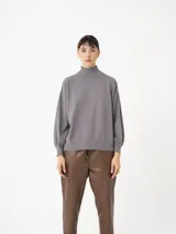 Sweater gris de cuello alto, manga larga abullonada y puños ajustados. Confeccionado en tejido de punto de viscosa y poliéster.