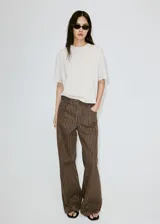 Jeans de corte recto y tiro medio, color marrón con diseño de rayas diplomáticas verticales claras. Cuenta con bolsillos clásicos y presillas para cinto.