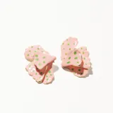 Aros tipo caravana con forma de flor, color rosa con lunares verdes y borde dorado.