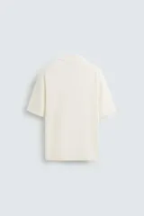 Polo de punto de corte regular fit, confeccionado en una mezcla de algodón y lyocell. Presenta cuello de solapa con cierre frontal de botones, manga corta y acabados en rib en puños y bajo.