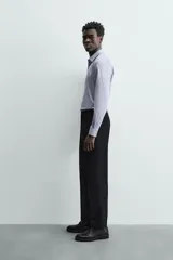 Camisa de algodón de manga larga, color celeste claro, con cuello italiano y cierre frontal de botonadura.