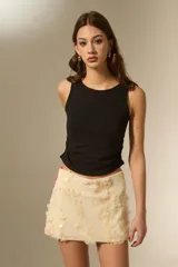 Top sin mangas de color negro, con cuello a la base y diseño ajustado al cuerpo con frunces laterales.