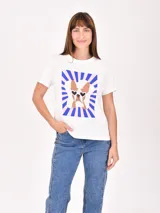 Remera blanca de manga corta con estampa frontal de un bulldog francés con lentes de sol sobre un fondo de rayos azules y rosados.