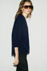 Chaqueta tipo cardigan de lana color azul marino, con cuello en pico, cierre frontal con botones y mangas abullonadas de largo tres cuartos.