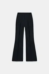 Pantalón de tiro alto en color negro, con diseño de corte recto y ligeramente acampanado. Presenta costuras verticales marcadas en el frente y bolsillos laterales de vivo.