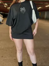 Remera blanca oversize de manga corta, con cuello redondo y diseño gráfico de araña en el pecho.