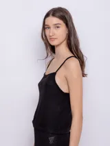 Top sin mangas de tela texturada color verde lima, con tirantes finos y escote cuadrado con detalle de terminación festoneada.