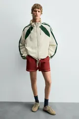 Zapatilla de cordones de estilo retro, con parte superior de serraje color bordó y detalles en piel lisa color rojo. Suela ultrafina de goma en tono marrón oscuro.