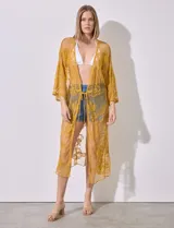 Kaftan largo color amarillo mostaza, de micro tul bordado con motivos florales. Tiene mangas largas y cordón ajustable en la cintura.