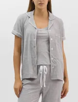 Set de pijama de tres piezas en color verde menta con estampado floral sutil, compuesto por una camisa de manga corta con botones, una musculosa básica y un pantalón largo de corte recto con cordón ajustable en la cintura.