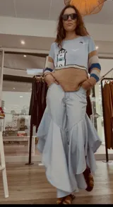 Pantalón de jean azul oscuro con diseño fluido y volados en las piernas.