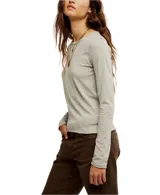 Remera de manga larga color gris oscuro, con cuello redondo y terminaciones al corte. Está confeccionada en una mezcla de algodón orgánico y reciclado, ofreciendo un calce entallado y cómodo.