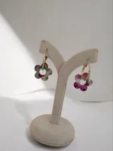 Aros tipo argolla con dije colgante en forma de flor realizado en acrílico con acabado brillante y destellos iridiscentes.