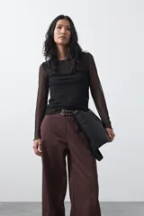 Pantalón wide leg color marrón chocolate, de tiro medio y corte relajado. Presenta detalle de hebillas laterales con ojales metálicos en la cintura y una caída fluida.
