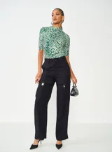 Blusa de mangas cortas con cuello alto y estampado animal print en tonos verde y blanco.