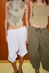 Top chaleco de punto acanalado con efecto lavado, cuello subido, cierre frontal con cremallera y bolsillo de plastrón en el delantero. Presenta un diseño sin mangas con bajo asimétrico.