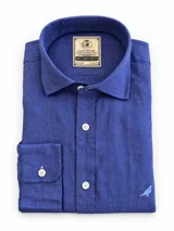 Camisa de lino de manga larga en color azul, con cuello corto clásico, cierre frontal de botones y bordado sutil de un pájaro en el frente.