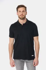 Remera polo de jersey de algodón color azul marino, con logo bordado en el pecho, botones personalizados y rayas en cuello y mangas en contraste.