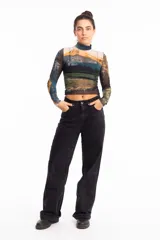Remera crop top de mangas largas y cuello alto, confeccionada en tejido de red transparente con estampado de paisaje montañoso.