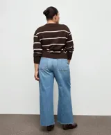 Jeans de denim azul de tiro medio, corte wide leg y diseño de pernera ancha con terminación deshilachada en el bajo.