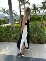 Vestido largo negro con panel lateral blanco, escote en V en la espalda y corte holgado.