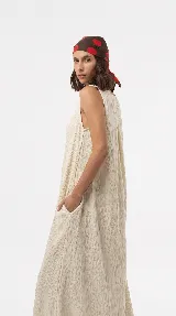 Vestido midi color crudo de silueta relajada y textura arrugada, con diseño sin mangas y escote redondo.