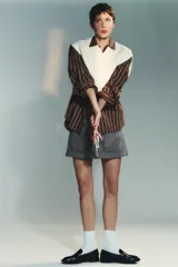 Zapato plano tipo mocasín de color negro, con detalle de tira delantera y copete subido. Presenta un acabado en punta redonda y una suela de 3 cm de altura.