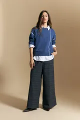 Sweater de punto color marrón con diseño de líneas blancas en contraste. Presenta cuello redondo, mangas largas y puños tejidos, con una estética minimalista y moderna.