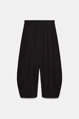 Pantalón de tiro bajo con cintura elástica, confeccionado en tejido fluido con diseño de pliegues verticales que le otorgan volumen y caída.