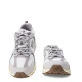 Championes New Balance 530 de mujer, color gris claro con detalles en blanco y beige. Confeccionados en malla y gamuza, con el logo "N" en los laterales y suela de goma.