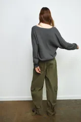 Jersey de punto liso color rojo, con escote en V profundo y mangas largas. Presenta terminaciones en rib en el cuello, puños y ruedo.