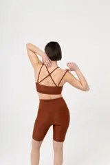 Top deportivo color marrón con doble bretel fino cruzado en la espalda.