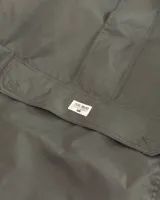 Rompeviento gris de estilo canguro con capucha, cuello alto y bolsillo frontal tipo sobre con cierre. Presenta puños elásticos y diseño funcional impermeable.