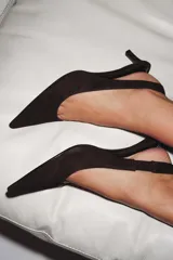 Zapato destalonado de ante color marrón con tacón kitten fino y punta afilada. Cuenta con una tira trasera elástica para mayor ajuste.